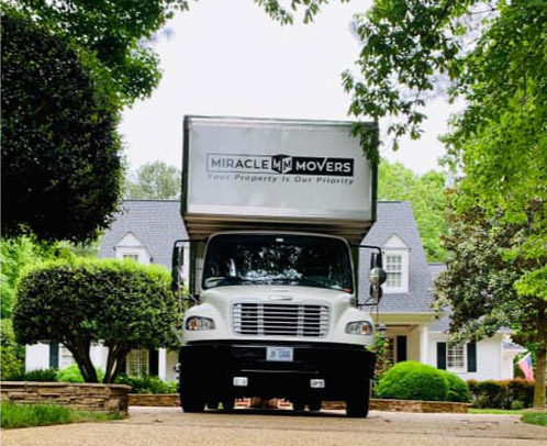 An image of Miracle Movers truck parked in Durham, NC in front of a client's house